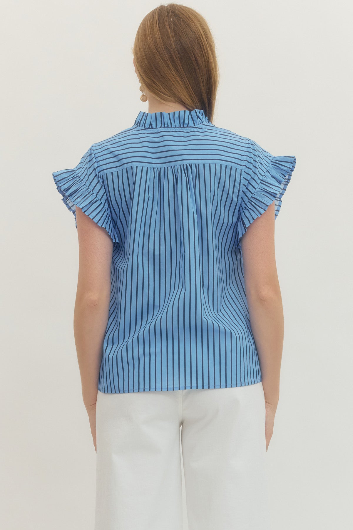 Back view of a woman wearing the Rhea blue and black striped short sleeve top with ruffle details.