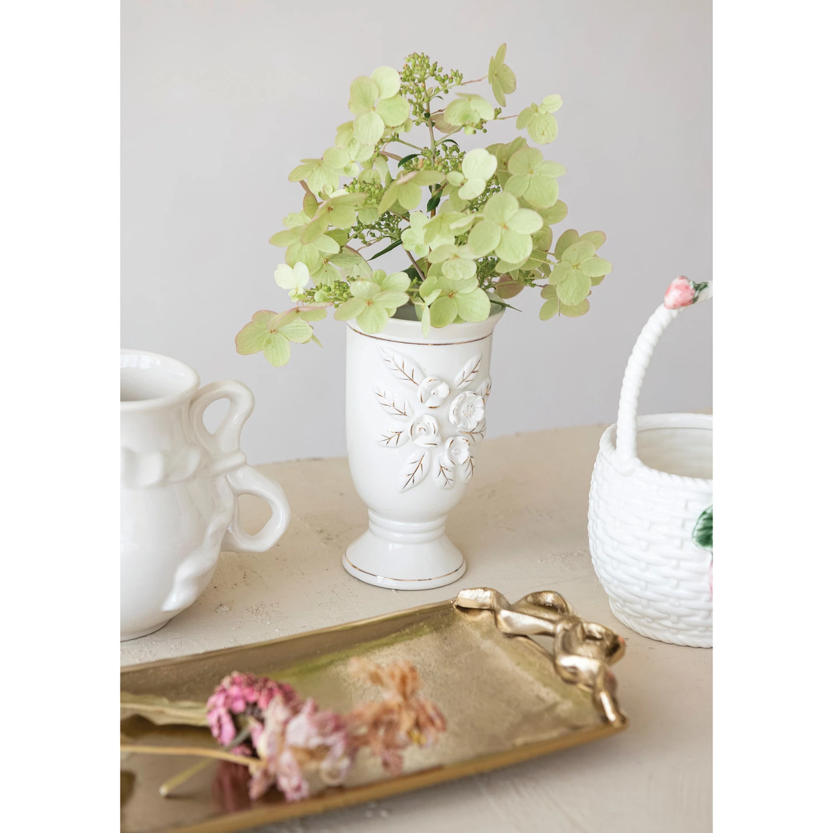 White footed vase with gold electroplated accents featuring a three-dimensional floral pattern.