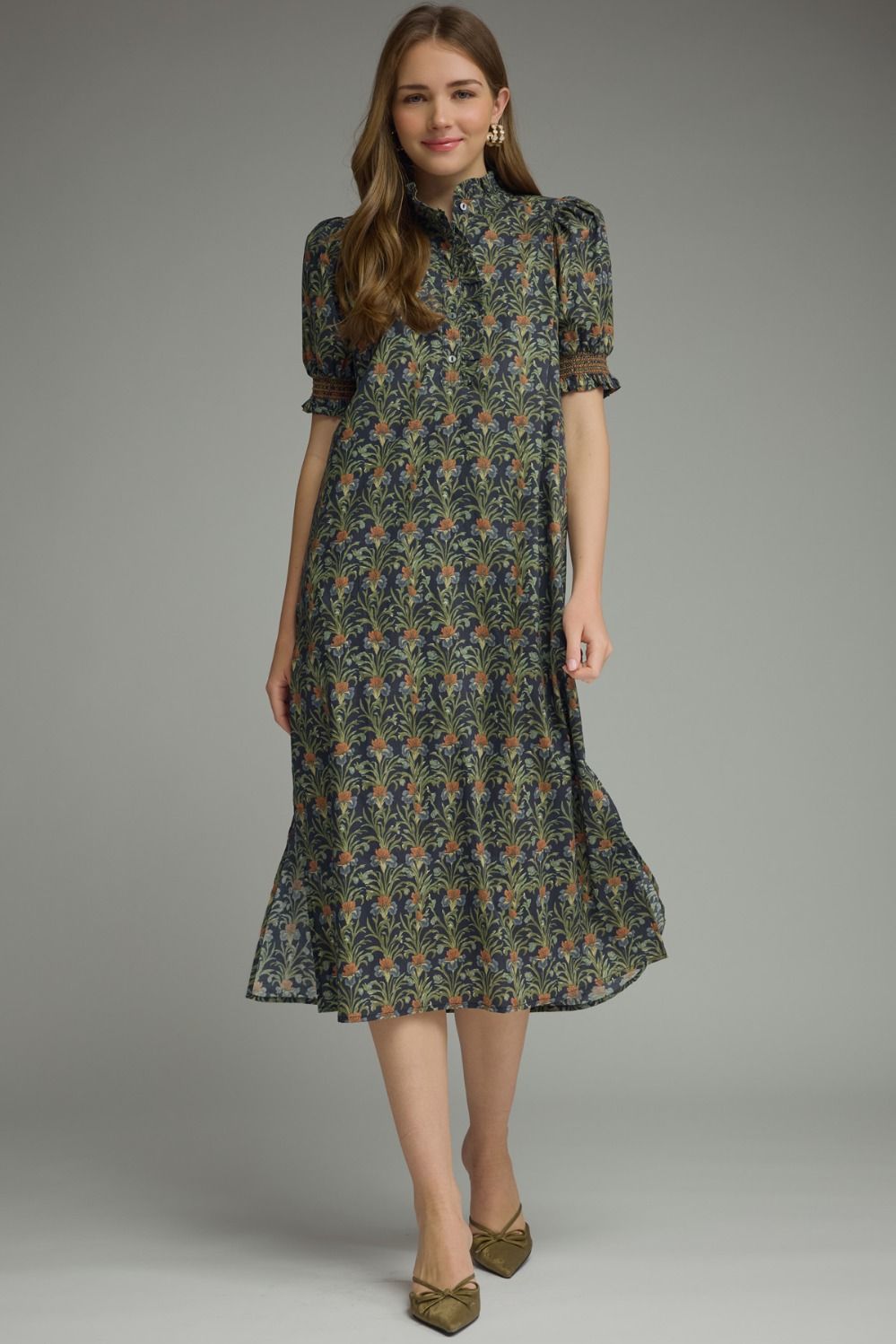 Woman wearing a Mary floral print midi dress with short puff sleeves and a ruffled collar.