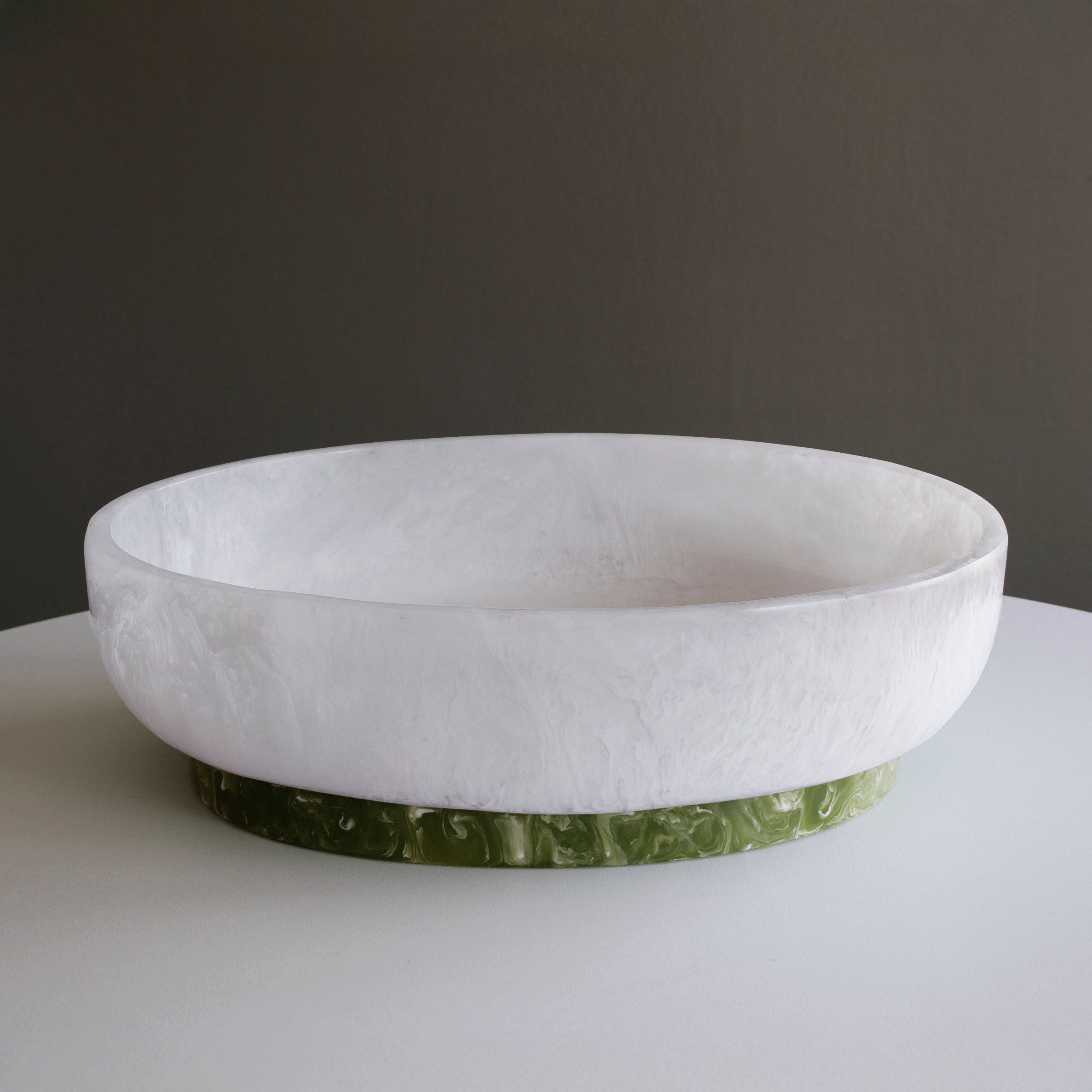 Large white marbled resin oval bowl with a contrasting green marbled base.