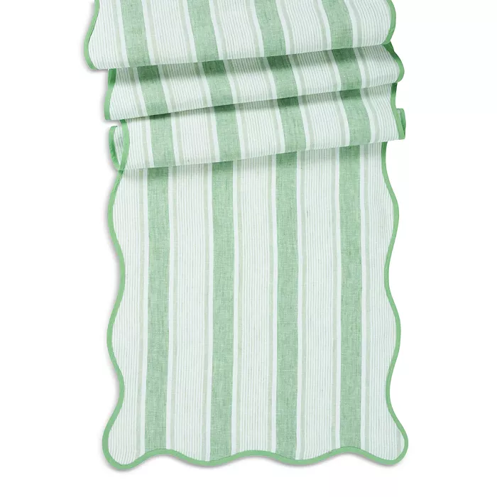Scalloped-edge Cabana Stripe table runner in candy-colored linen with cotton blend.
