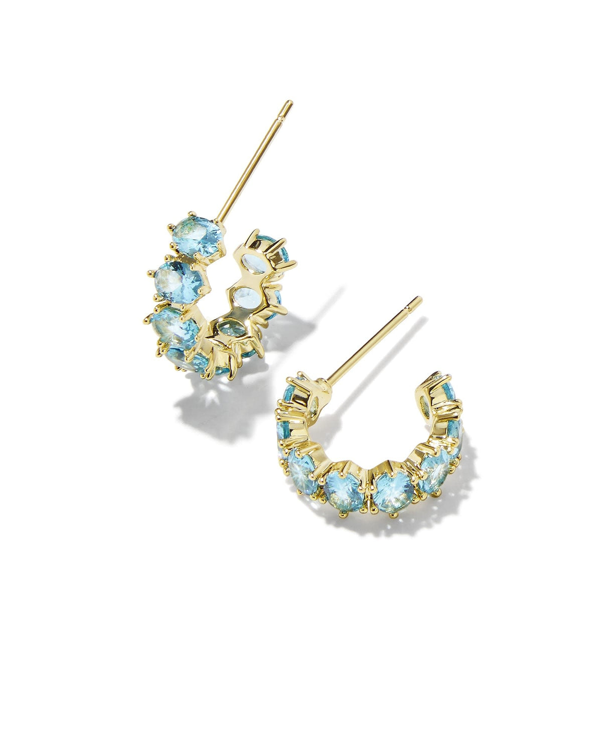 Gold huggie earrings featuring an aqua crystal accent on the front.