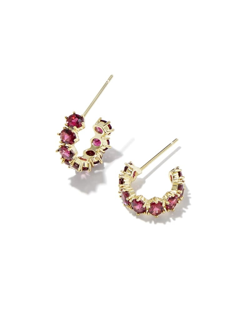 Gold huggie earrings with burgundy crystal accents on earpost closure