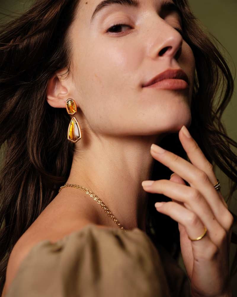 Gold enamel frame statement earrings with custom-cut stones on a post closure.