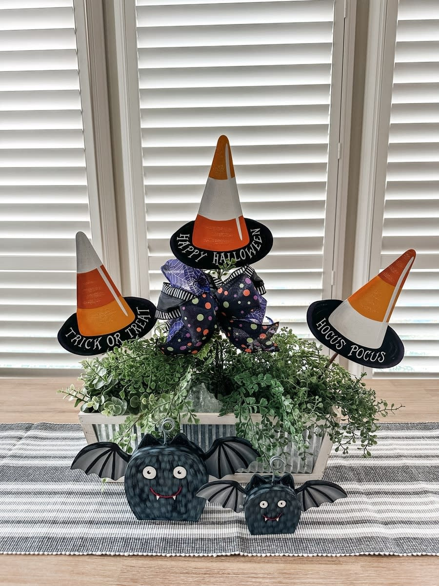 Candy corn witch hat stake with orange, yellow, and white striped brim.