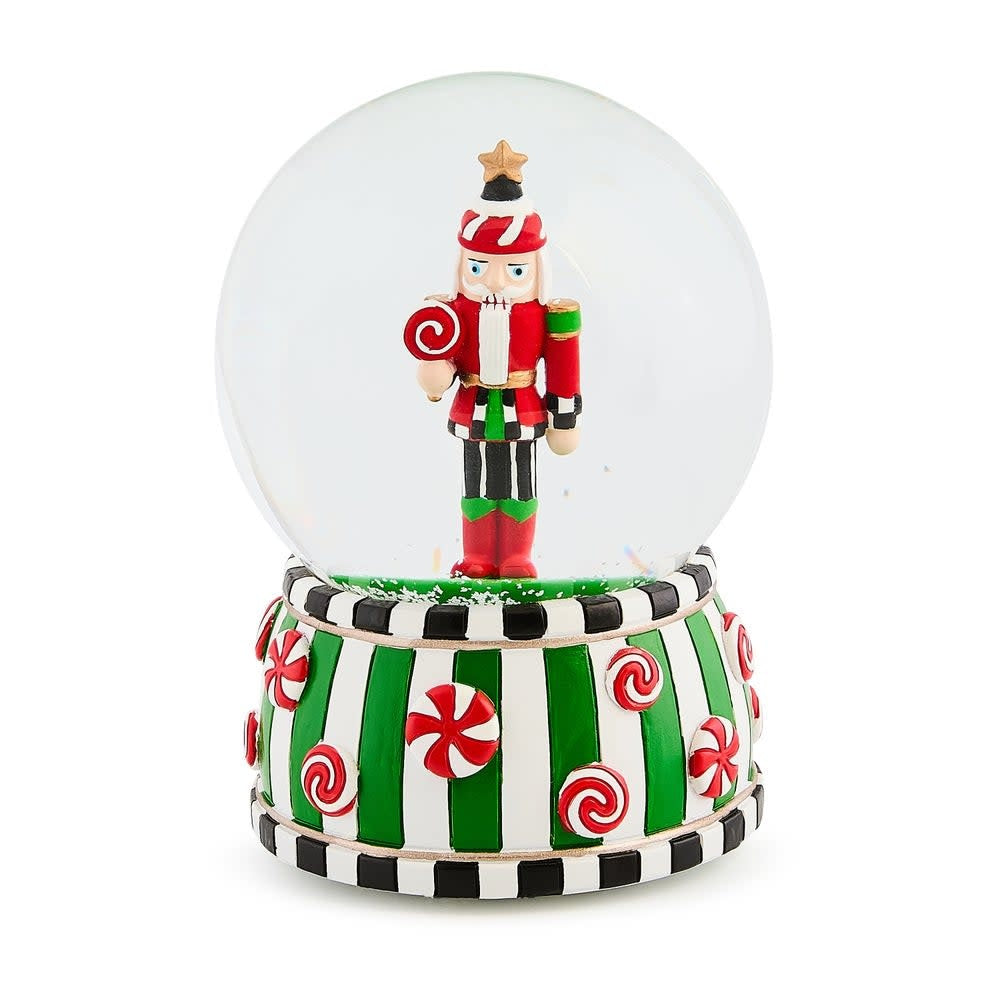 Resin snow globe featuring a nutcracker soldier in red uniform with blue hat inside clear glass sphere.