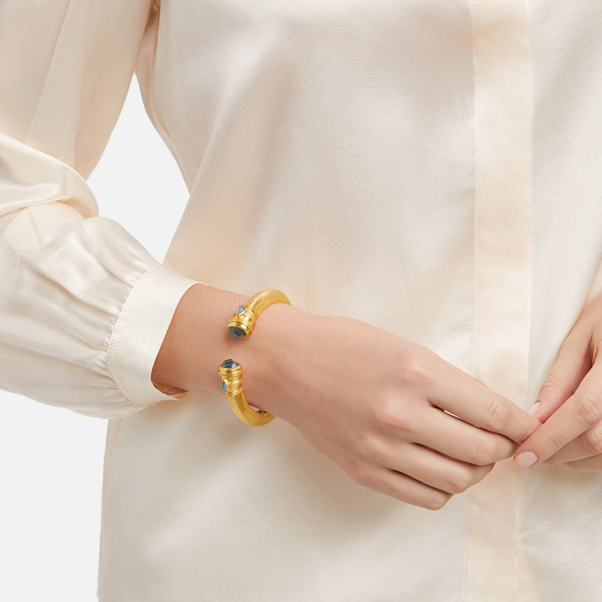 Cannes Demi Cuff in gold with shell pearl endcaps and pear-shaped gemstones.