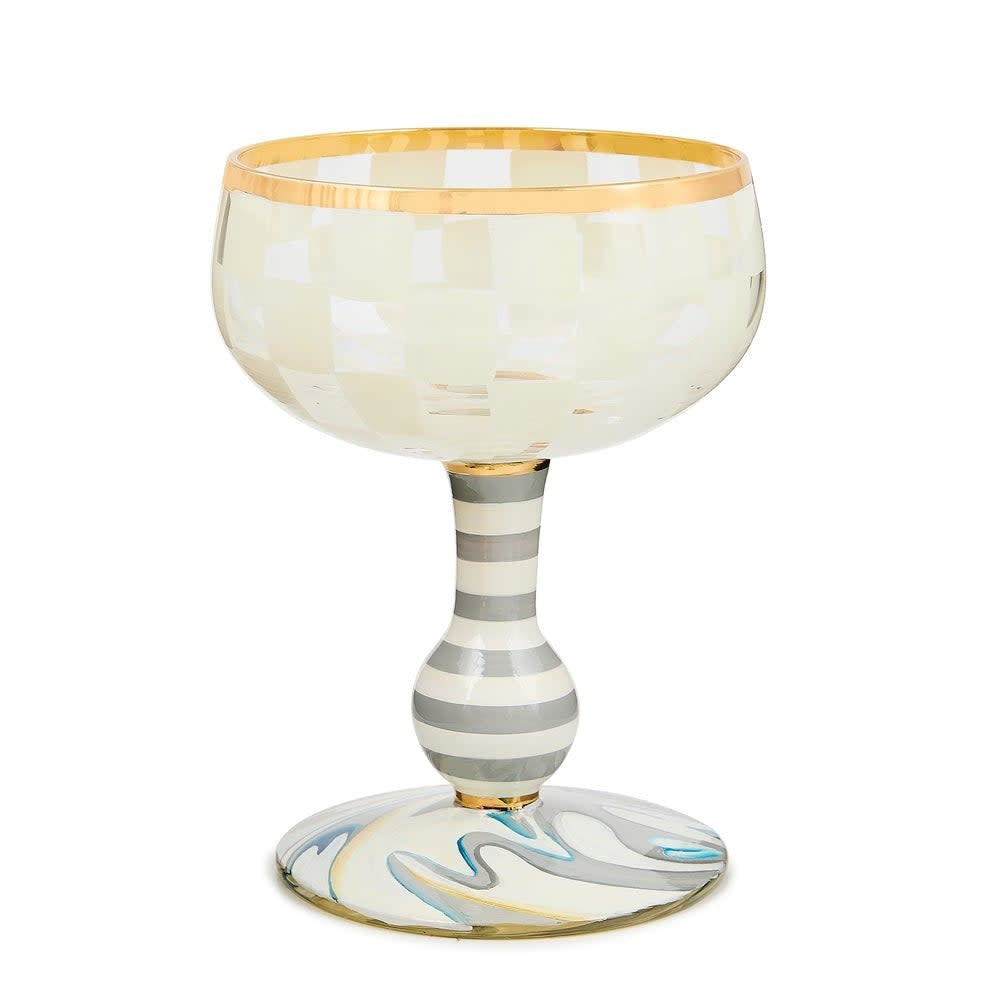 Hand-blown Carnival Coupe glass in white with a colorful carnival-themed pattern.