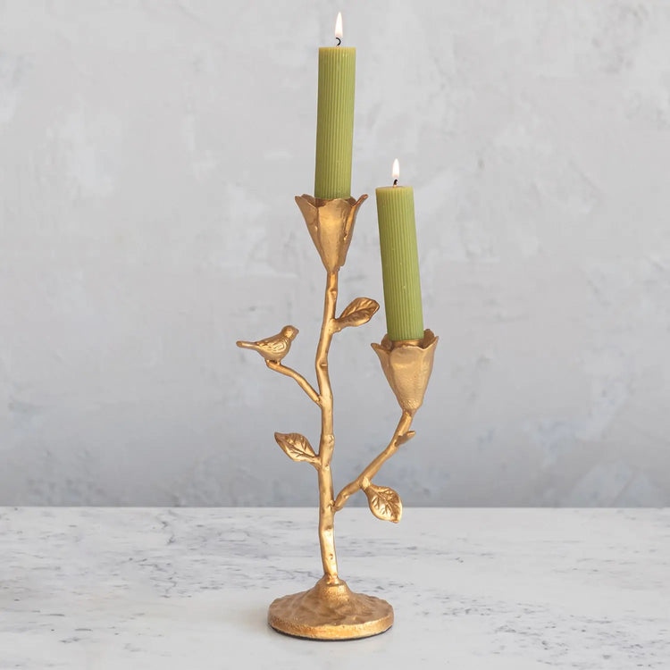 Gold cast iron candelabra featuring a bird perched among floral silhouettes.