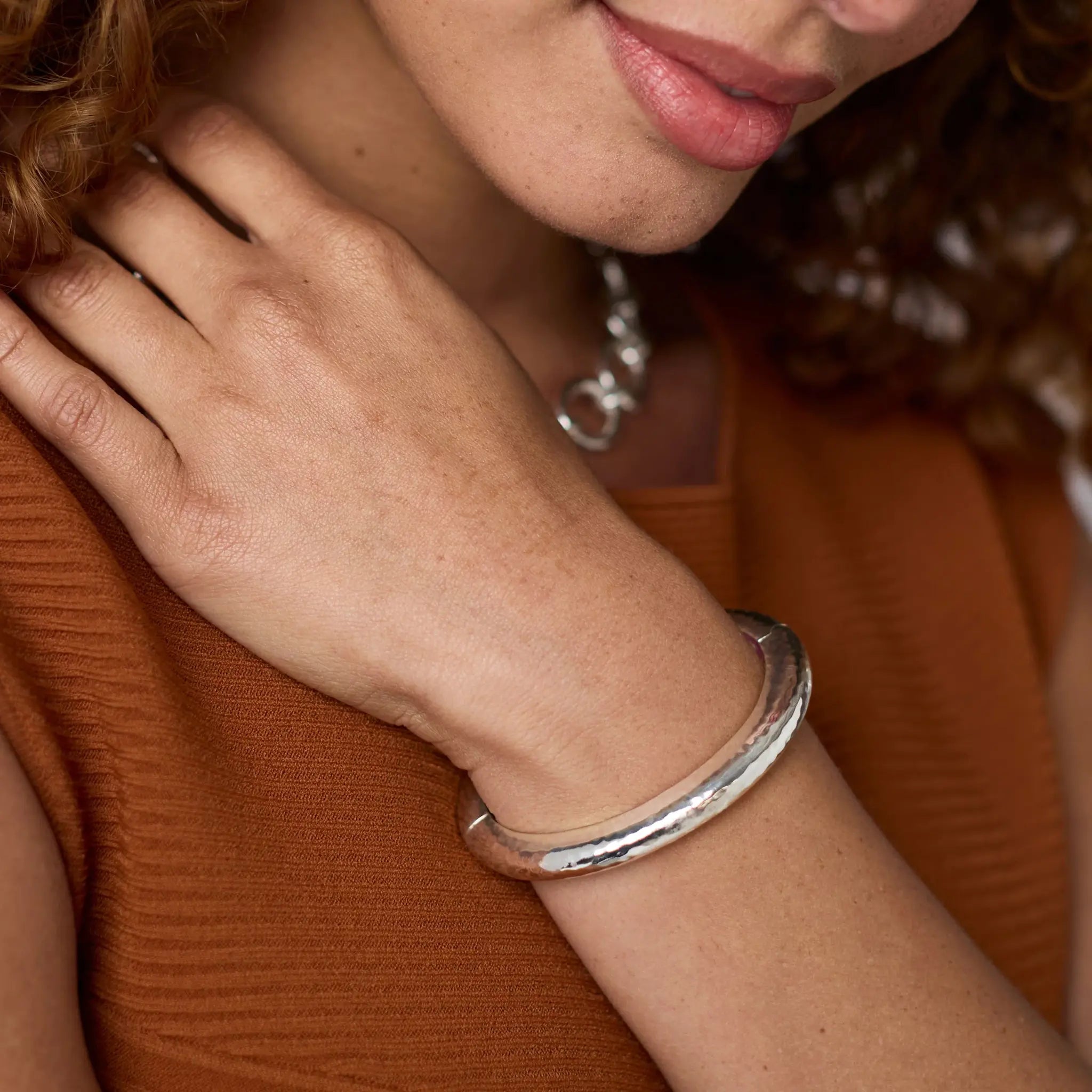 Silver oval hinge bangle with a lightly hammered texture.