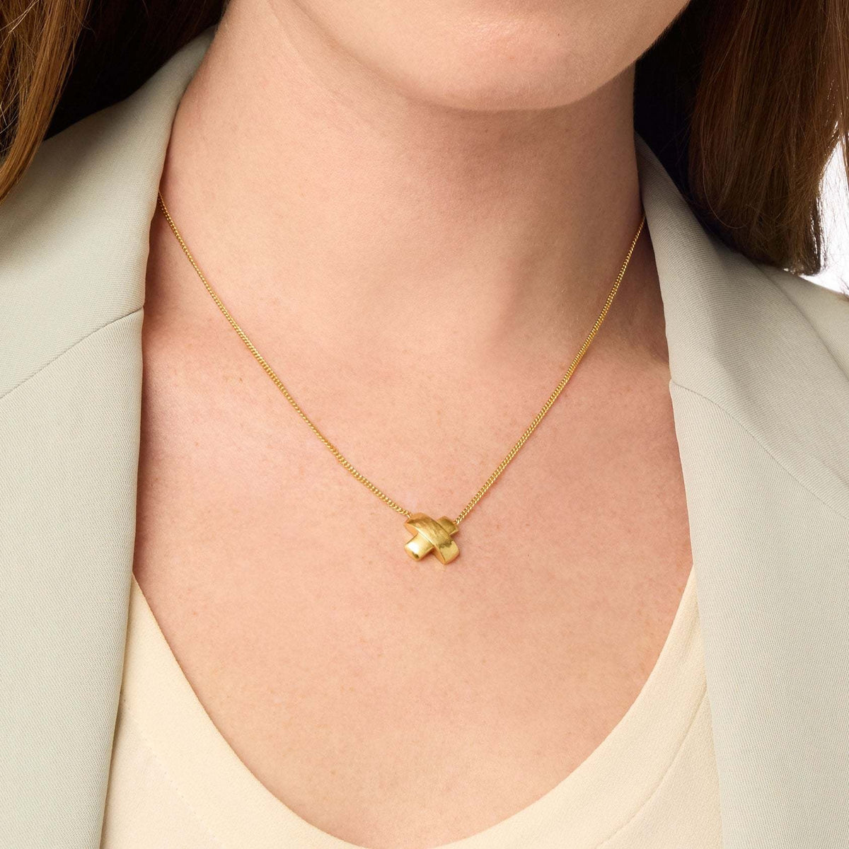 Gold X-shaped necklace with hammered and smooth satin bars on an adjustable curb chain.