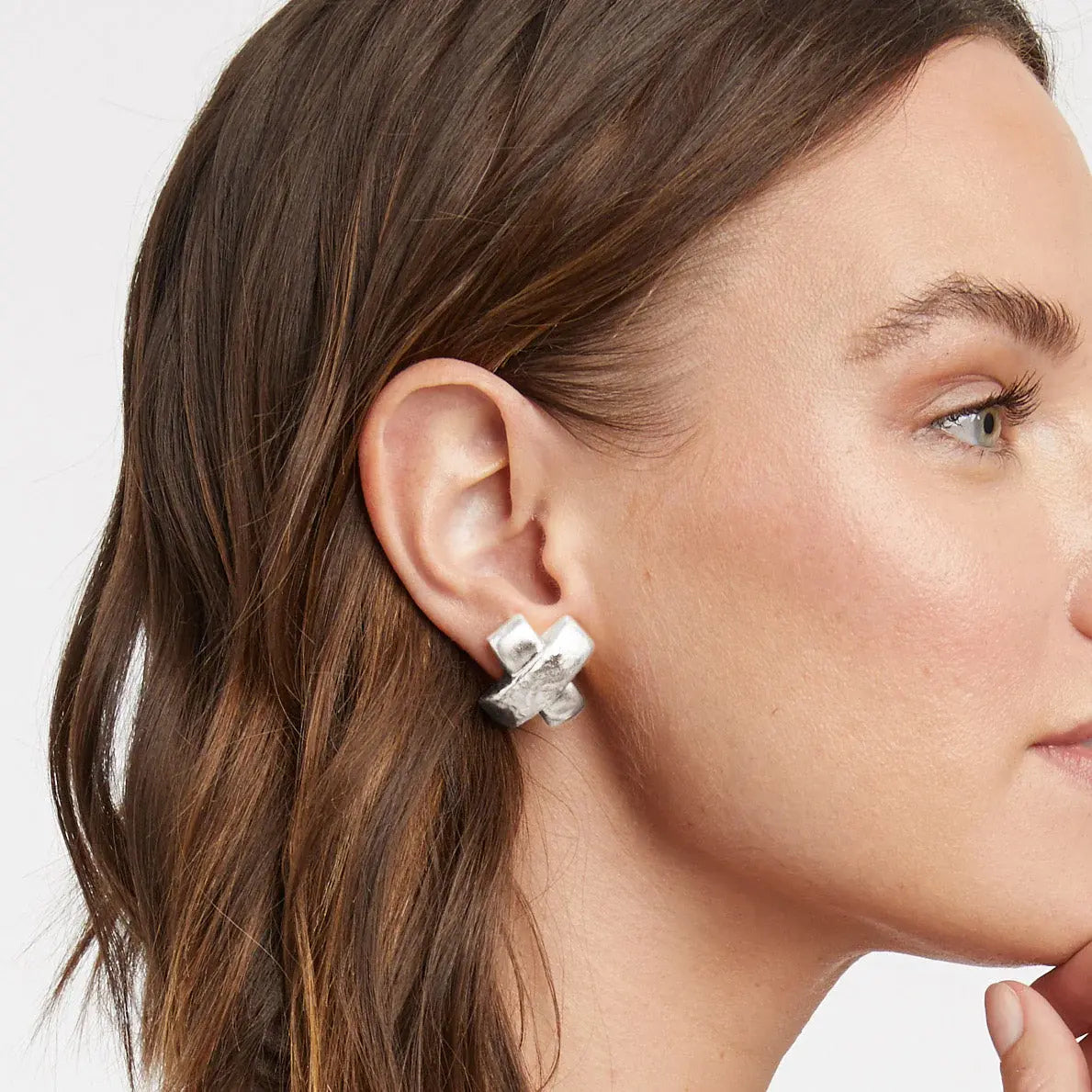 Silver X-shaped earring with a hammered bar overlapping a smooth satiny finish