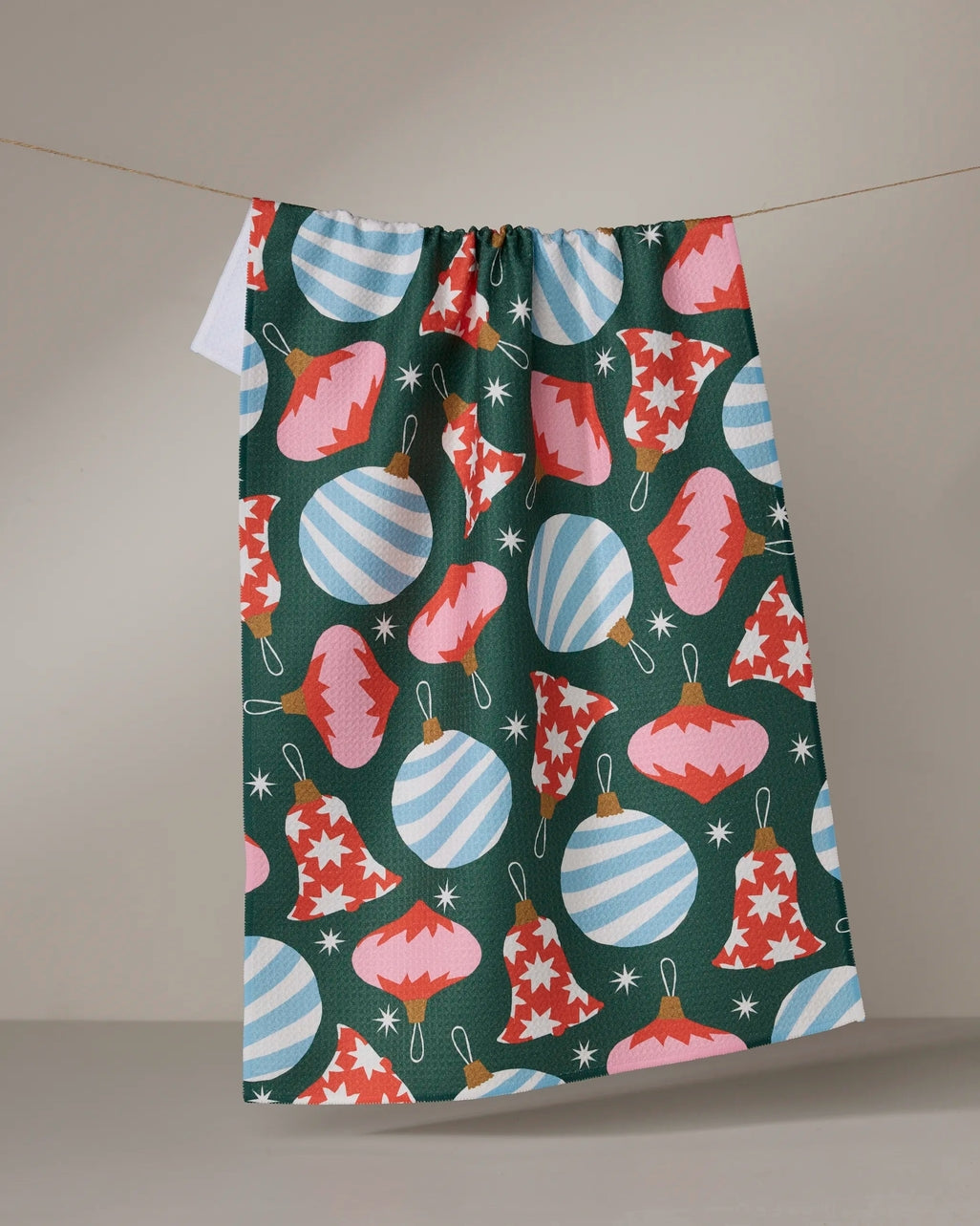 Holiday-themed tea towel with waffle weave texture in red featuring festive snowflake pattern.