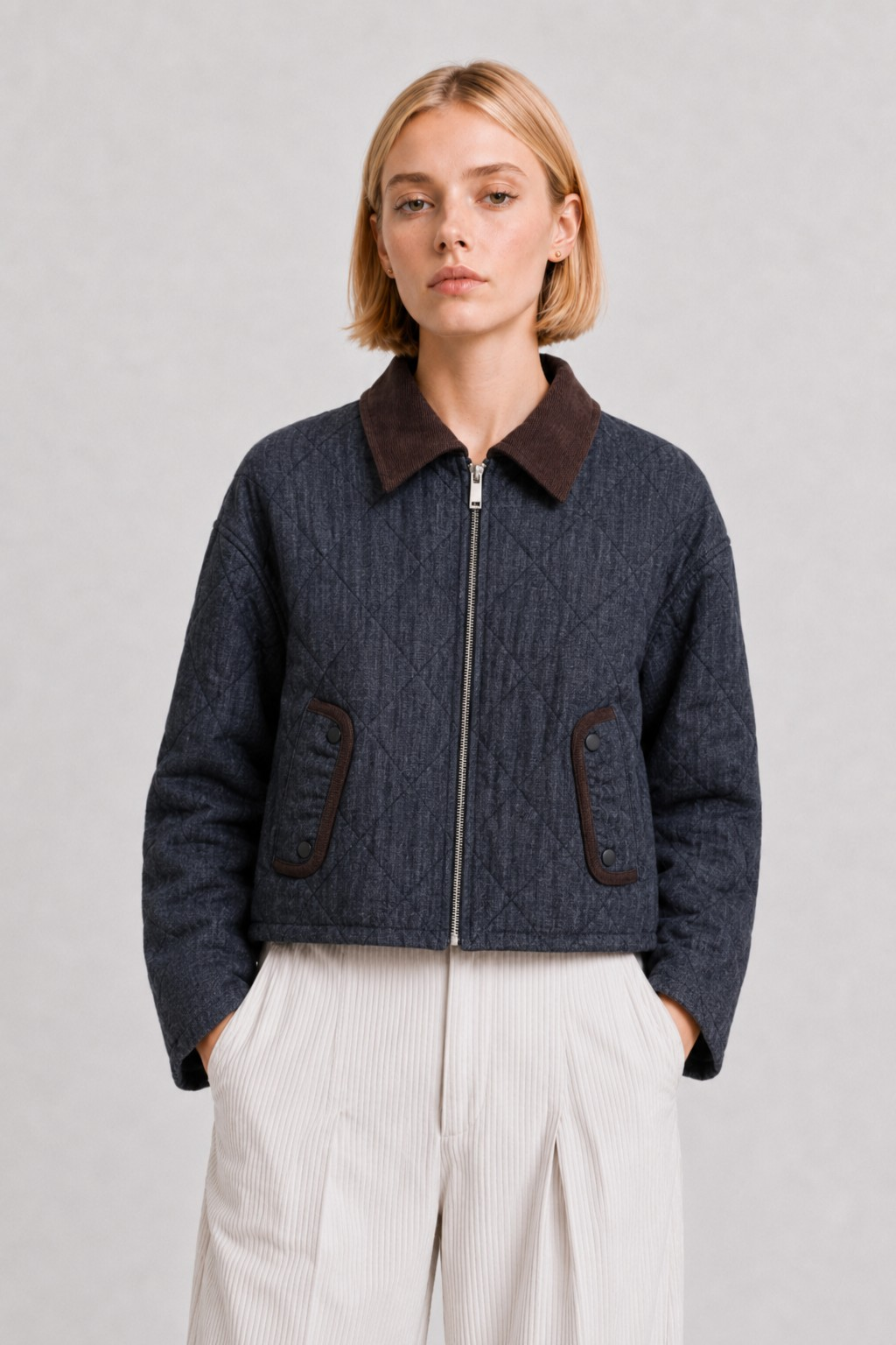 Woman wearing a Thalia navy quilted jacket with a brown corduroy collar and zip-front closure.