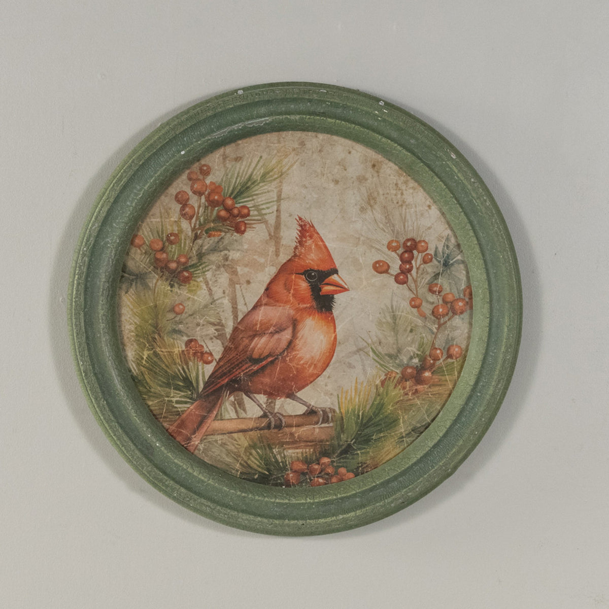 Round glass wall clock with a wooden frame featuring a holiday scene of red cardinals on branches.