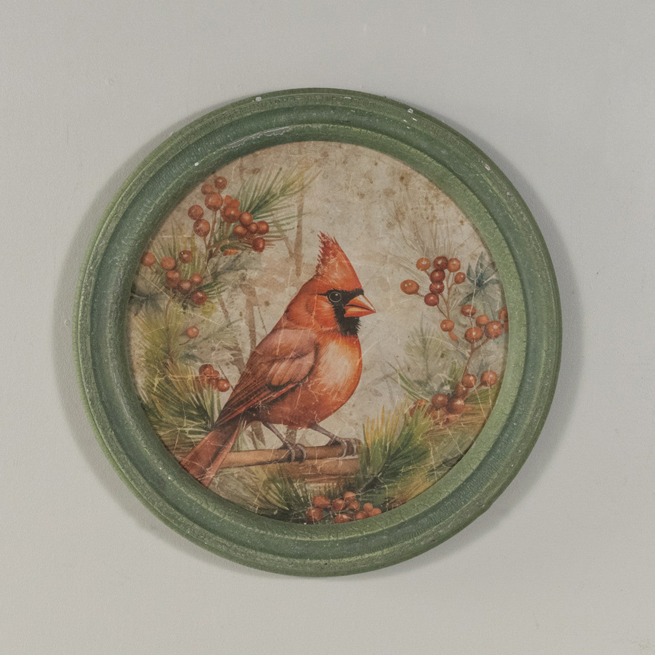 Round glass wall clock with a wooden frame featuring a holiday scene of red cardinals on branches.