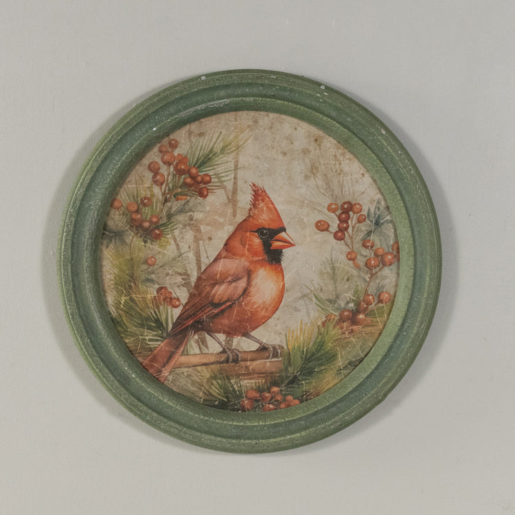 Round glass wall clock with a wooden frame featuring a holiday scene of red cardinals on branches.