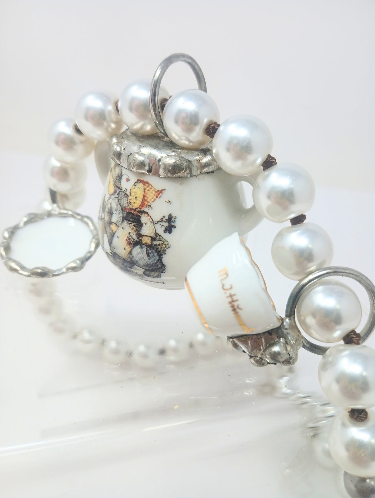 Porcelain teapot charm necklace with M.I. Hummel artwork on a silver chain