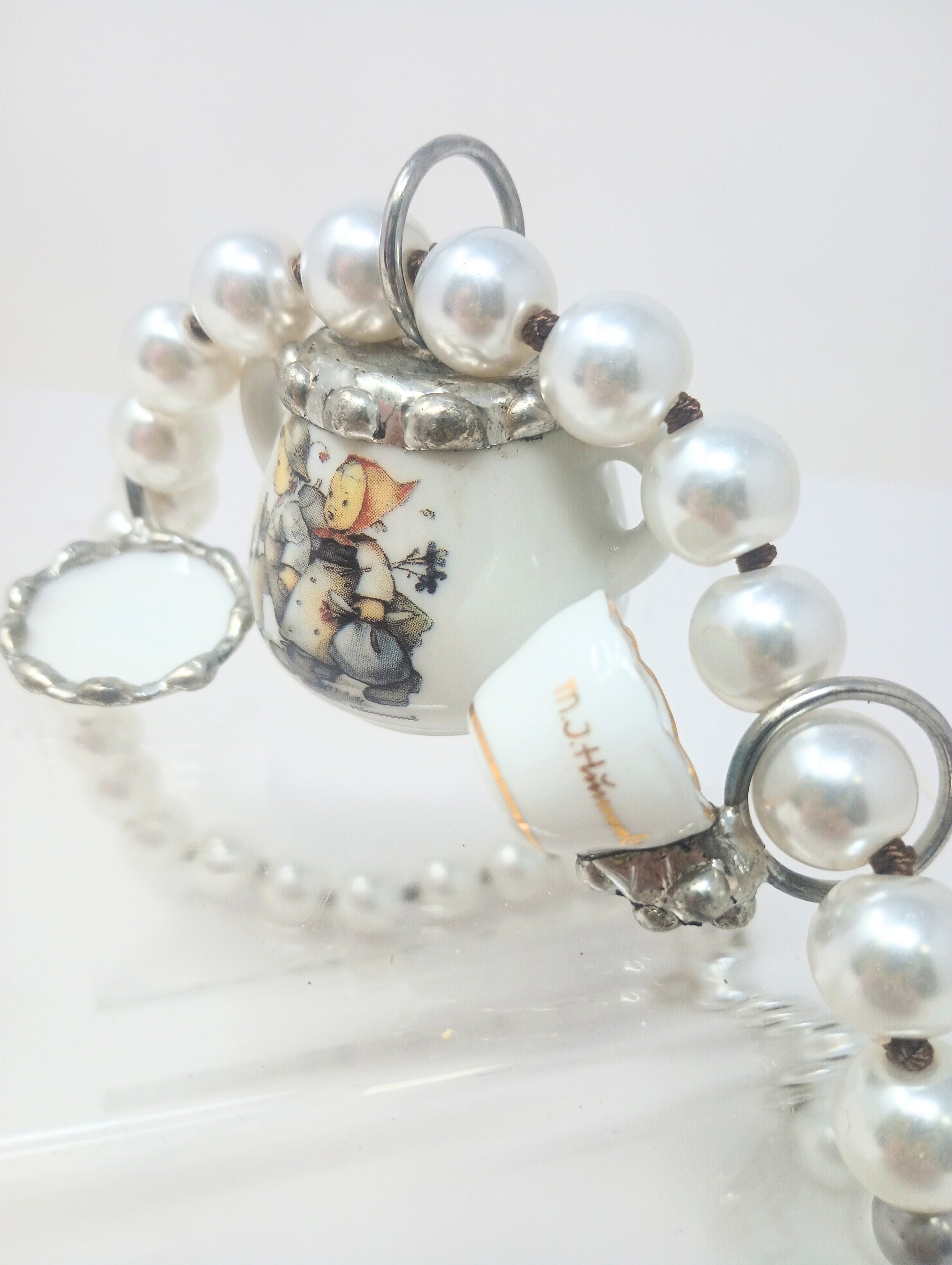 Porcelain teapot charm necklace with M.I. Hummel artwork on a silver chain