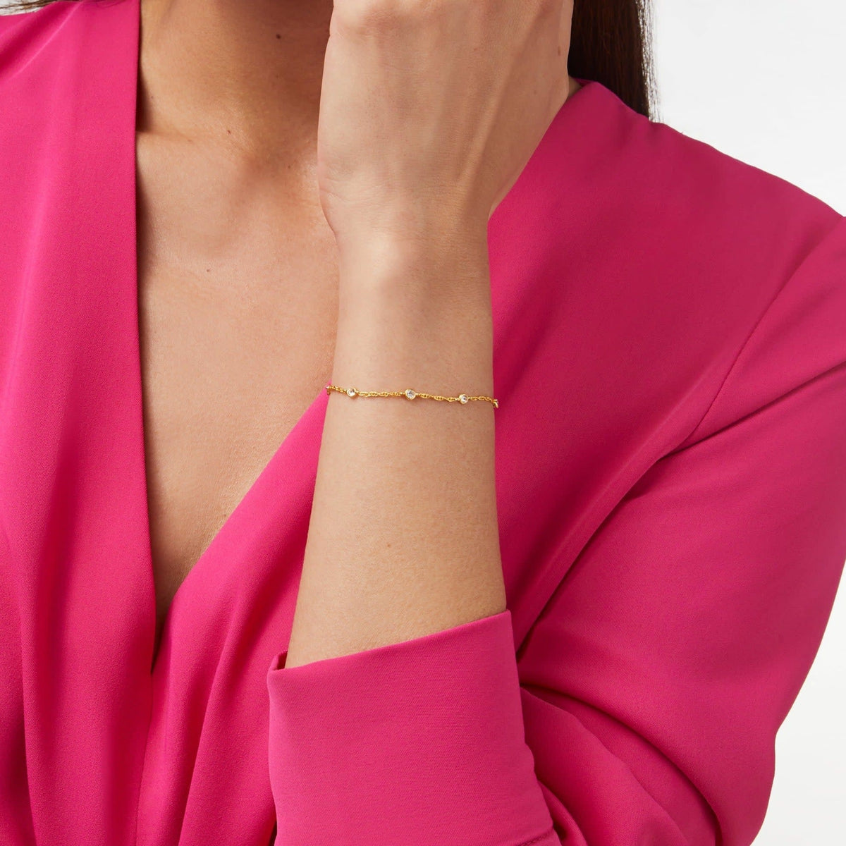Delicate adjustable bracelet with seven small cubic zirconia stones on a 24K gold plate chain.