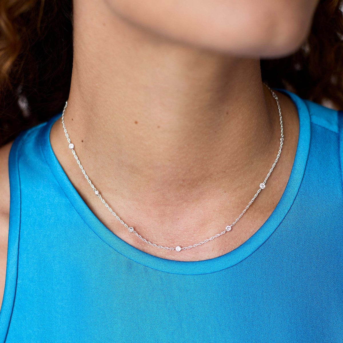 Silver station necklace with delicate cubic zirconia accents on a pure silver plate chain.