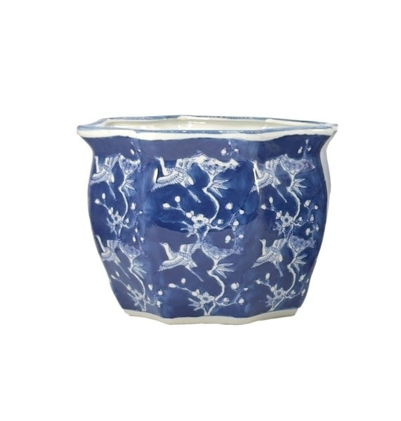 White ceramic planter with blue crane motif, fluted sides, and Chinoiserie pattern.