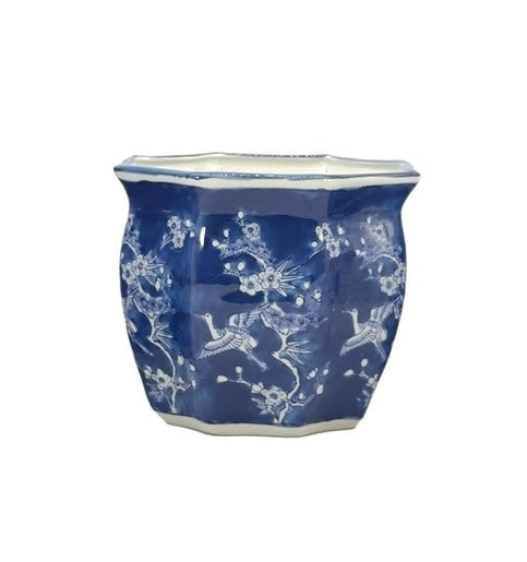 White ceramic planter pot with blue crane motif, fluted sides, and Chinoiserie design.