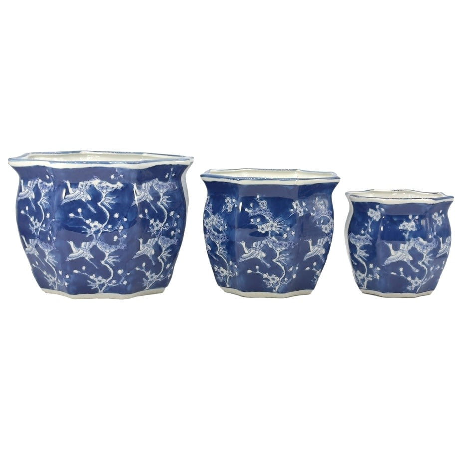 White ceramic planter with blue crane motif, fluted sides, and chinoiserie pattern.