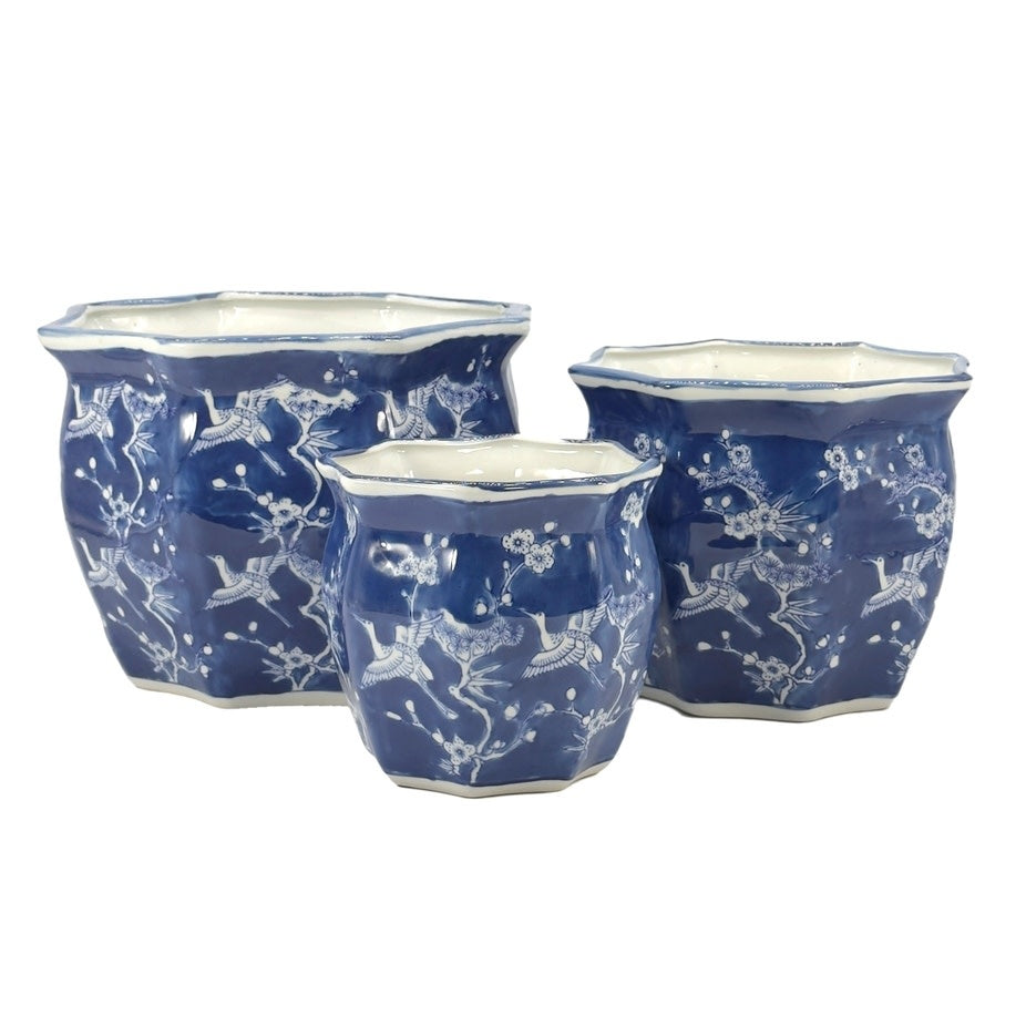 White ceramic planter pot with blue crane motif, fluted sides, and Chinoiserie design.