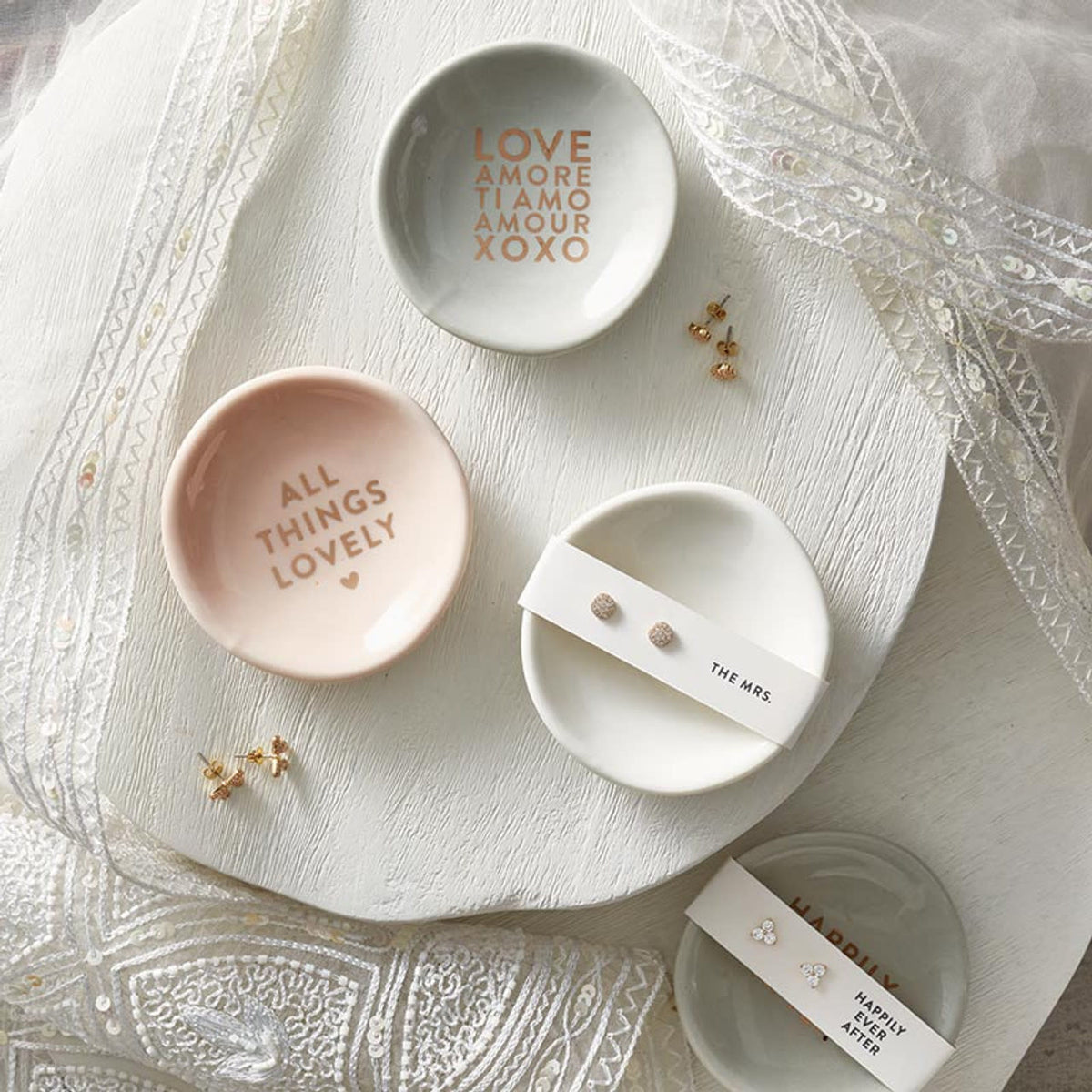 Ceramic ring dish with zinc alloy earrings in neutral tones