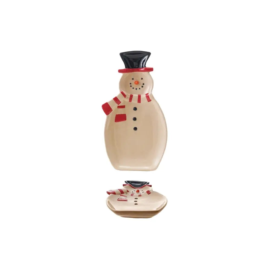 Ceramic snowman-shaped dish with white glaze holding holiday treats.