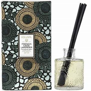 French Cade Lavender reed diffuser in clear glass bottle with light purple liquid and wooden sticks.