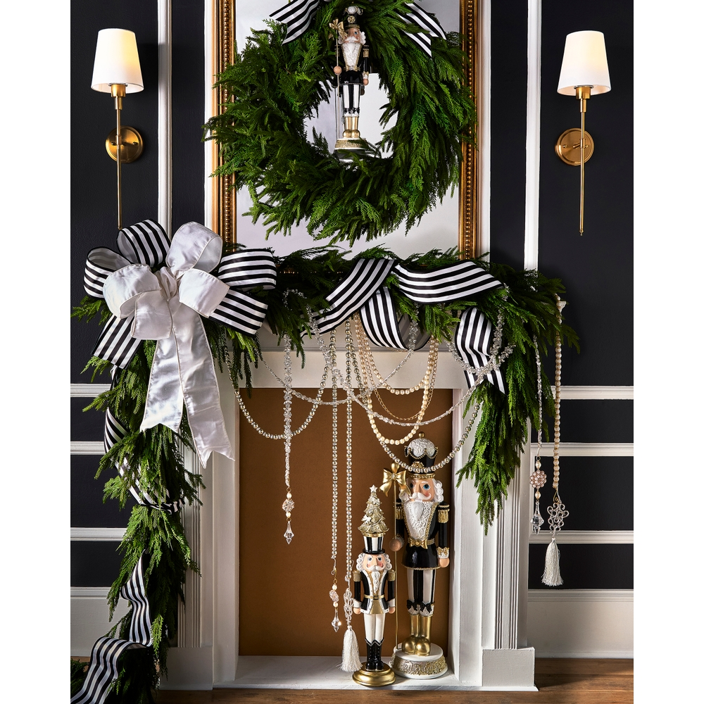 17.75-inch black and white nutcracker with a bow, standing on a decorated fireplace mantel.