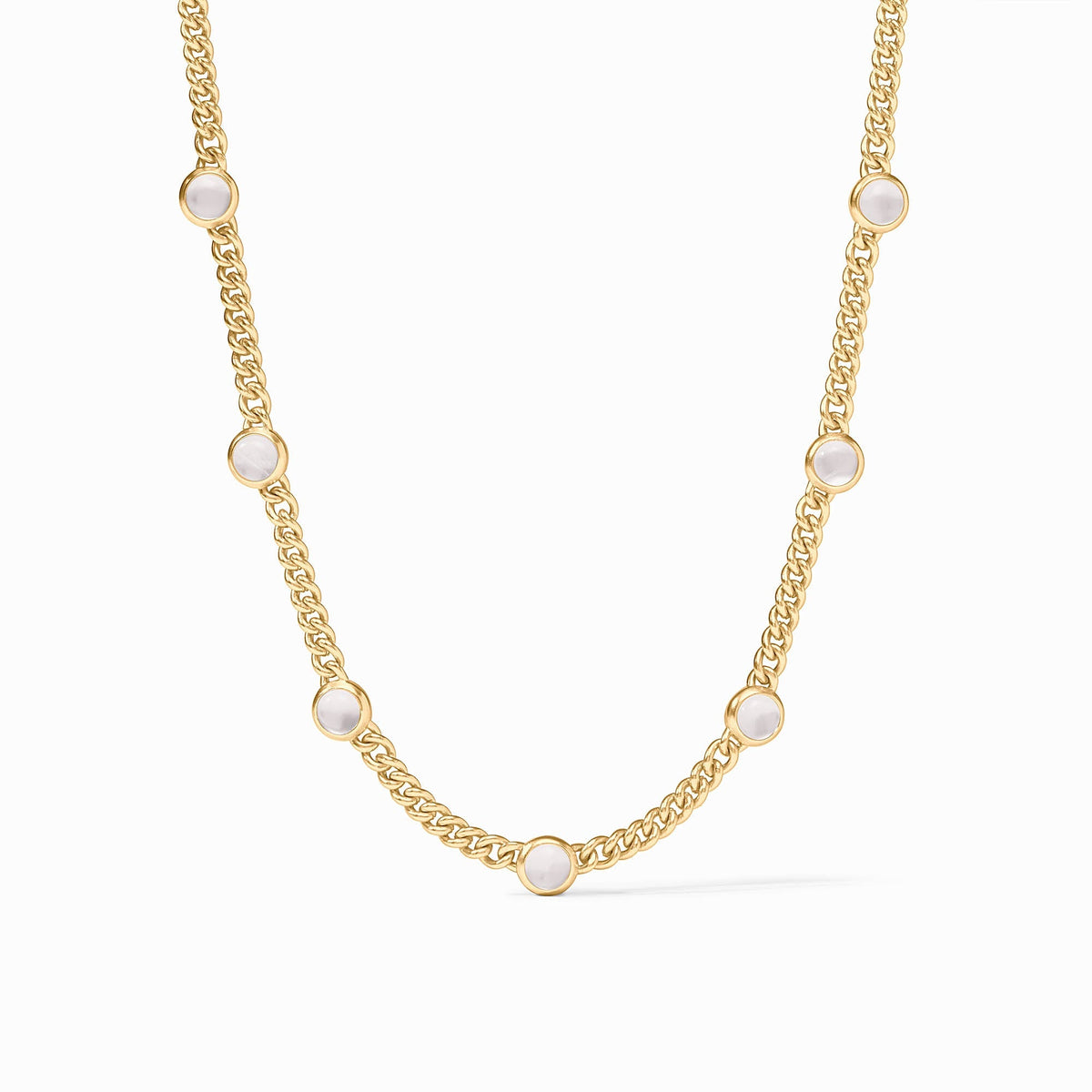 Gold curb chain necklace featuring seven round white glass stations in bezel settings.