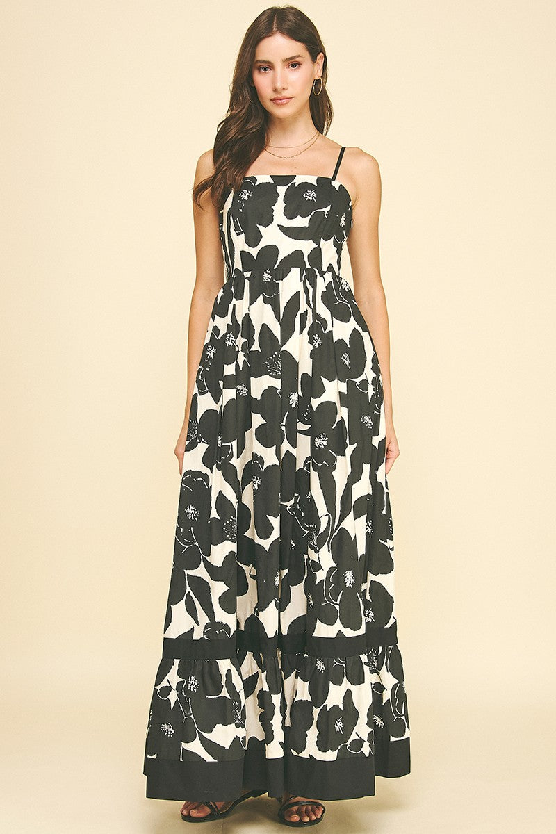 Woman wearing the Maxine Floral Tiered Maxi Dress in a black and white floral print.