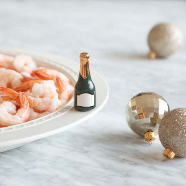 Mini champagne bottle with 'Champagne Celebration' label in gold script on white background.