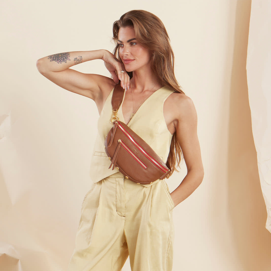 Large Charles crossbody bag in mahogany pebbled leather with brushed gold hardware and red lining.