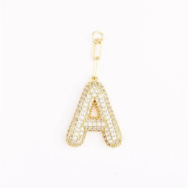 Heather-colored charm bag with gold plating, pave crystal accents, initial letter detail, and one-inch extender.