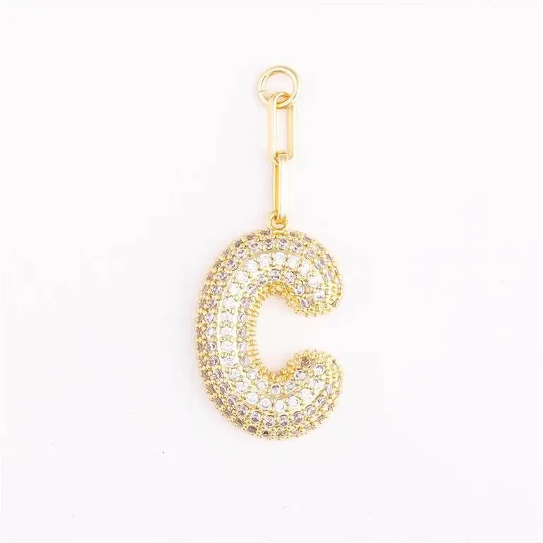 Heather-colored charm bag with gold plating, pave crystal accents, initial engraving option, and one-inch extender.