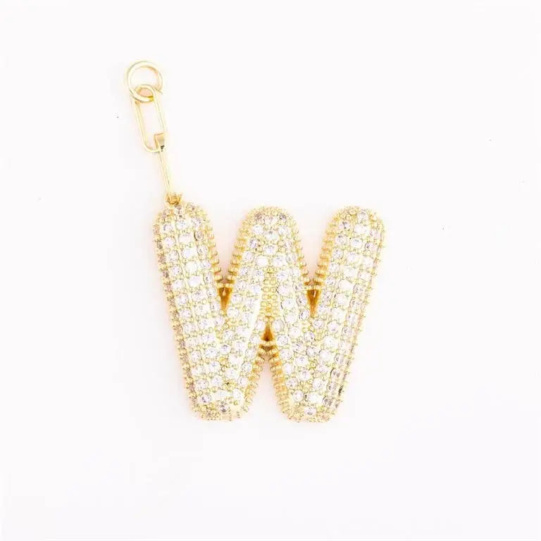 Heather-colored charm bag with gold plating, pave crystal accents, initial engraving option, and attached extender chain.