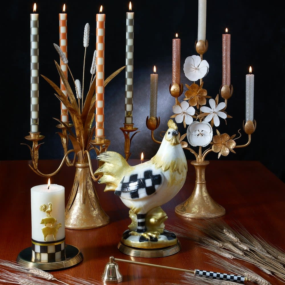 Brass candle snuffer with black steel handle featuring a white check pattern.