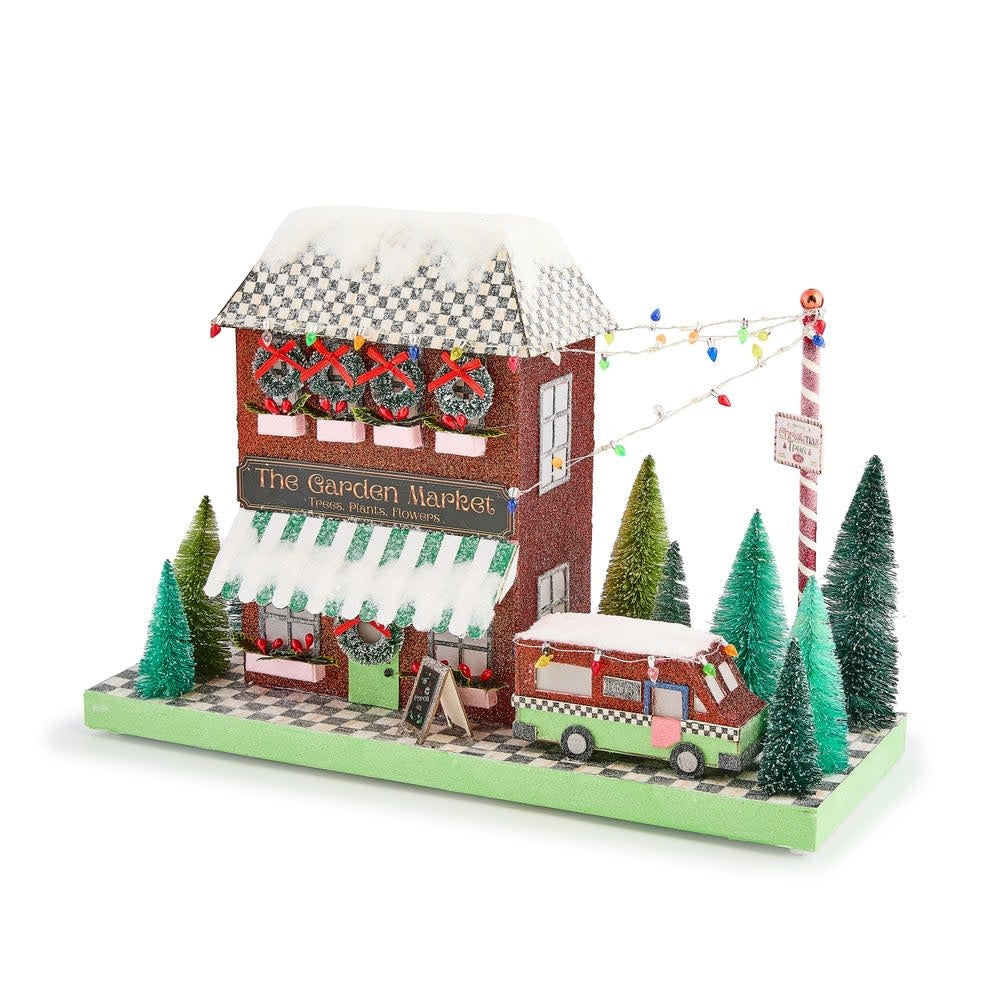 Illuminated paper house with Courtly Check roof showing a Christmas tree farm scene.