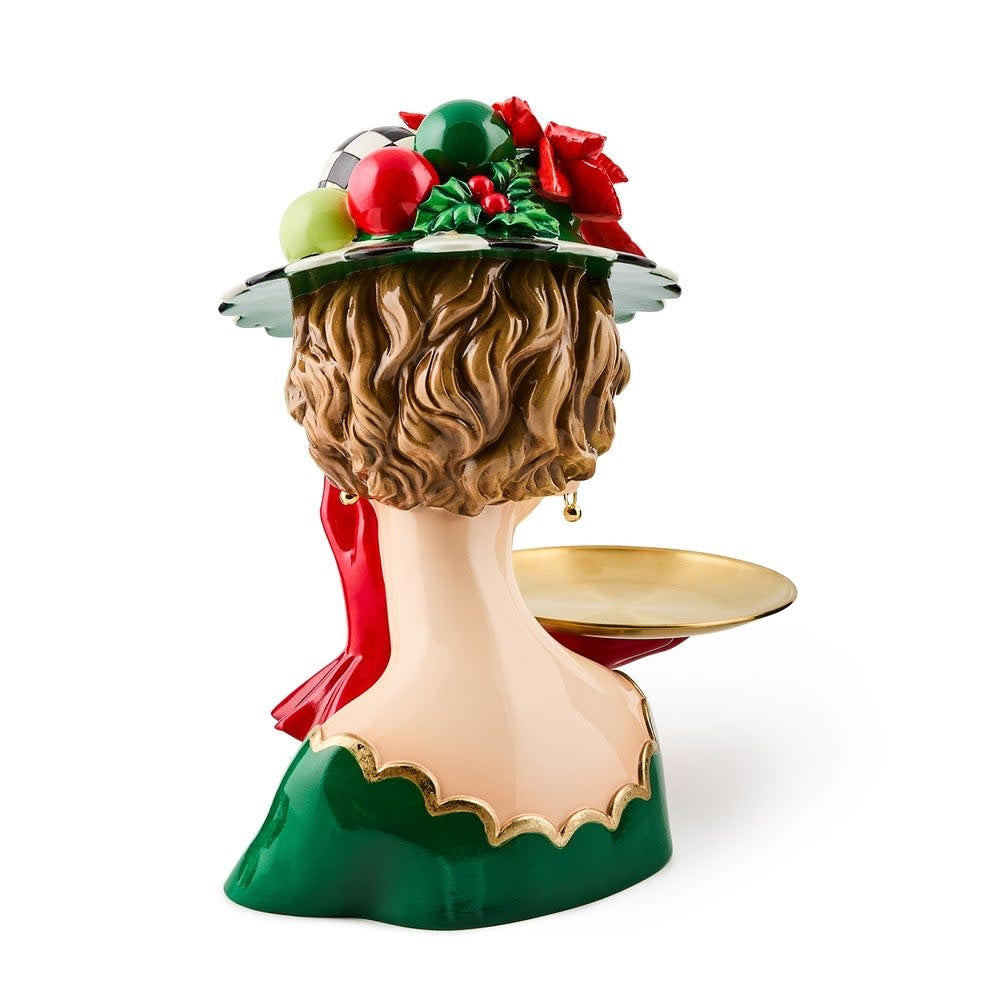 Resin figurine of a lady in formal attire holding an oval gold tray with holiday decor.