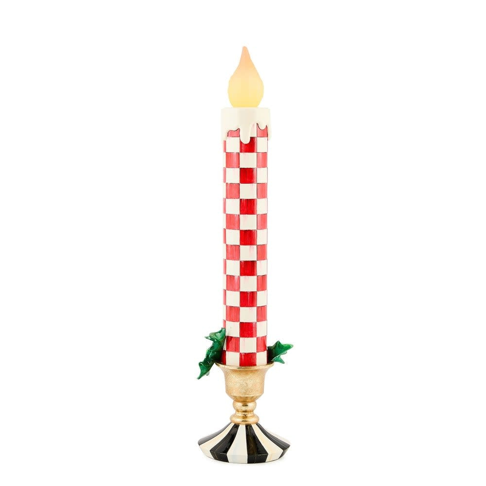 Red resin retro candle with illuminated flame effect on a flat surface