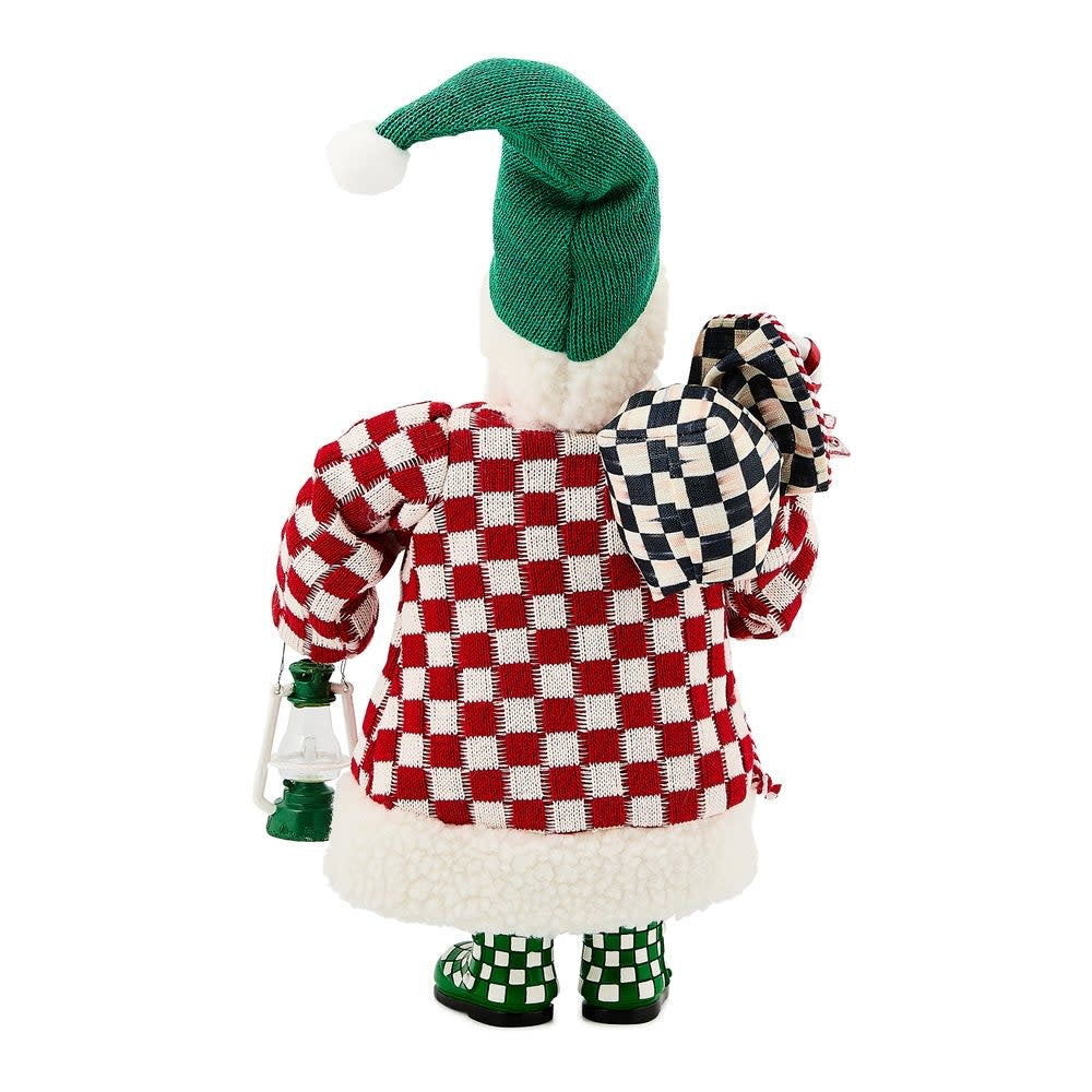 Small fabric Santa figurine in red checkered coat holding a holiday gift bag.