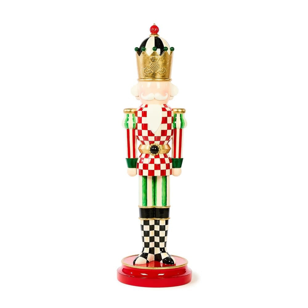 Small resin nutcracker with courtly red checks, green stripes, crown, and thistle logo.