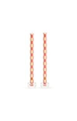 Two checkered pink beeswax dinner candles with a cylindrical shape.