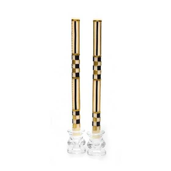 Set of two black dinner candles with gold hand-painted stripe pattern on a white background