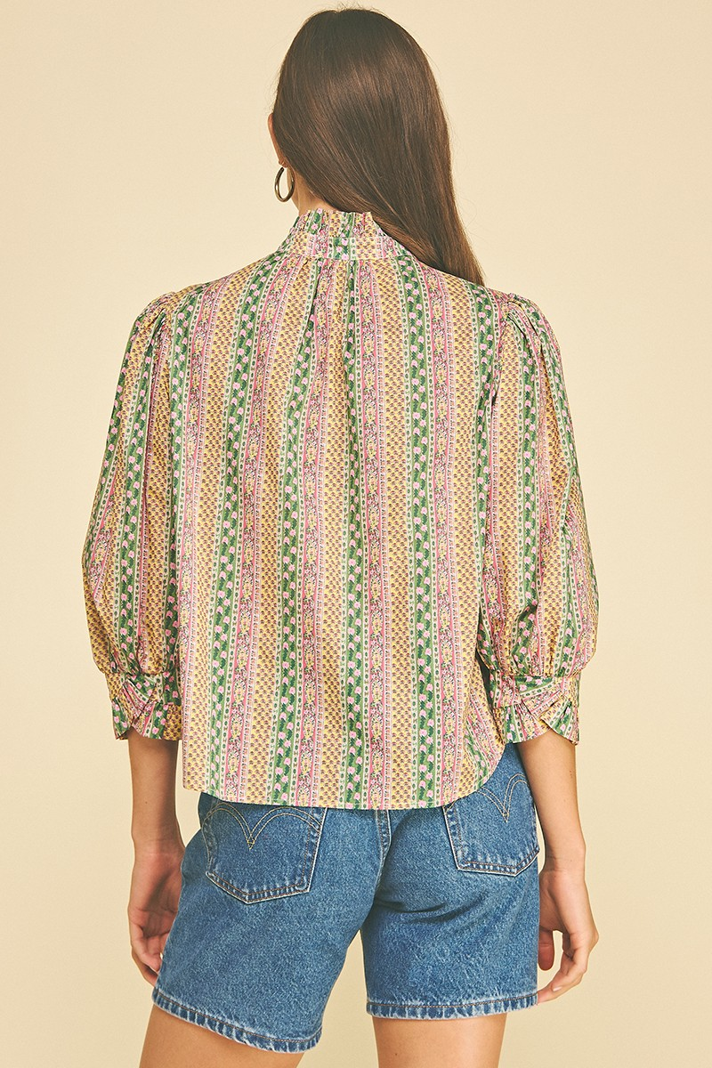 Back view of a woman wearing a Mabel floral botanical print button down blouse with denim shorts.