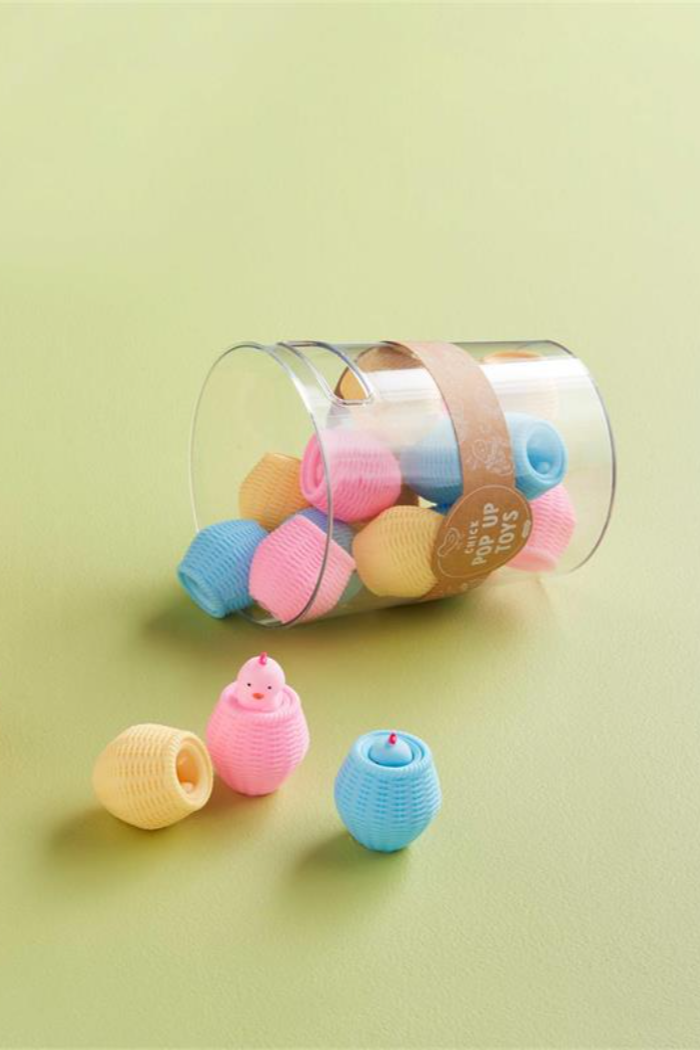 Plastic squeeze basket toy shaped like a chick with pop-up surprise mechanism